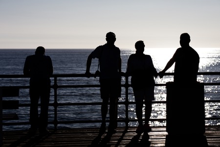 Tourists silhouetted on Santa Monica Pier, Santa Monica, Californiaの写真素材