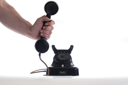 Male hand holding the receiver of a vintage phone into the direction of the camera.

Studio shot, isolated on white.の写真素材