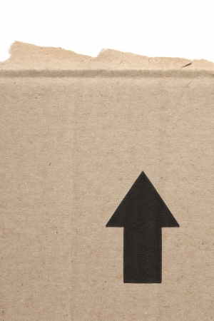 Cardboard ripped from a carton pacakage with arrow pointing upの写真素材