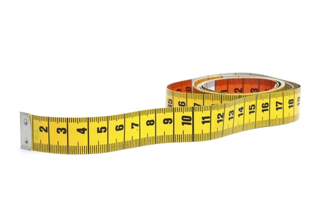 Partly rolled out yellow measure tape, isolated on white background