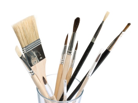 Paint brushes in different sizes in a glass. Isolated on white background.