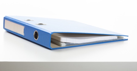 Ring binder in blue color, lying on a desk.

Studio shot, isolated on white.の写真素材