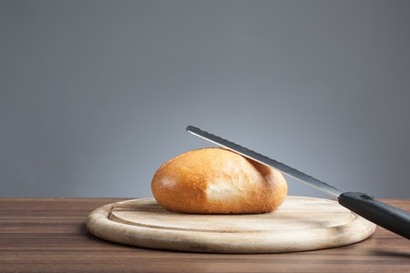 Breakfast plate with cutting knife and a bread roll 
