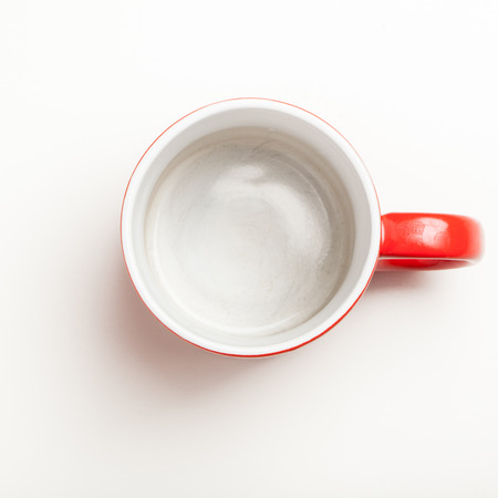 Top view on empty red coffee or tea mug or cup. Studio shot from above on white background.の写真素材