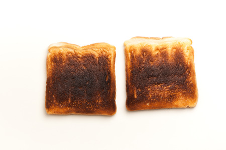 Two slices of bread, toasted dark burnt. Studio shot on white background.の写真素材