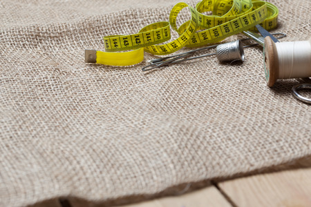 Jute textile cloth with scissors, needle, thread spools for home made embroidery, needlework and...