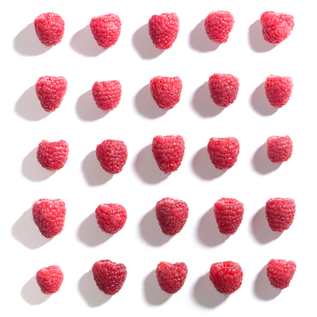 Square pattern of red raspberries, overhead from above, isolated on white background