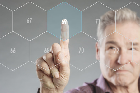 Senior man choosing retirement age on futuristic virtual digital screenの写真素材