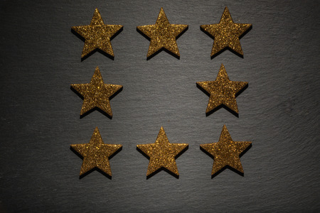 Frame of eight golden stars, christmas decoration element, on black slate texture  backgroundの写真素材