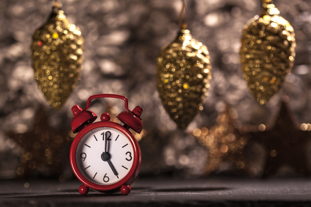 Red alarm clock set to 5 o'clock, Christmas decoration background, shallow depth of fieldの写真素材