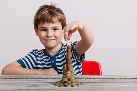 Boy building stack of money. Financial safety, investment building concept.の写真素材