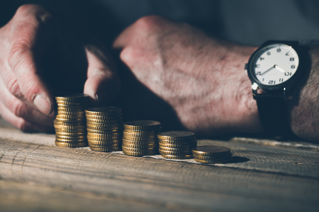 Man in business casual stacking money as concept for success or savings, investment and accounting.