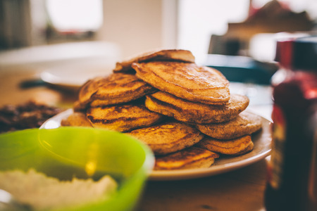 Table prepared for breakfast with pancakes and bacon, shallow depth of field.