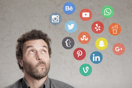 Man with social media logos, writing and thinking about choice of networkingのeditorial素材
