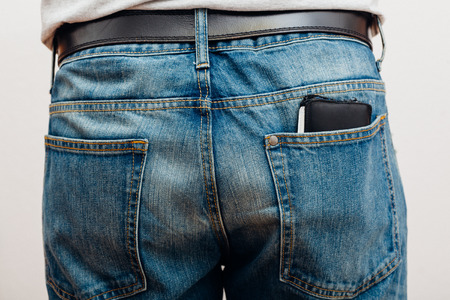 Closeup to back of man, jeans with wallet in pocket, people studio indoors shot.
