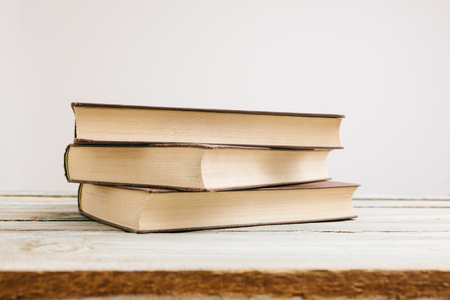 Stack of vintage books on an old tableの写真素材