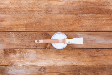 High angle view on wood table freshly painted in white varnish with brush.の写真素材