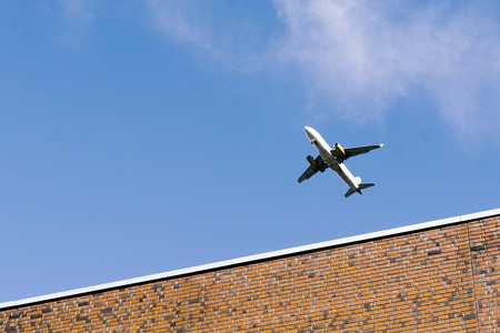 Airplane flying low over buildings in Berlin Pankow during approach to airport Tegelの写真素材