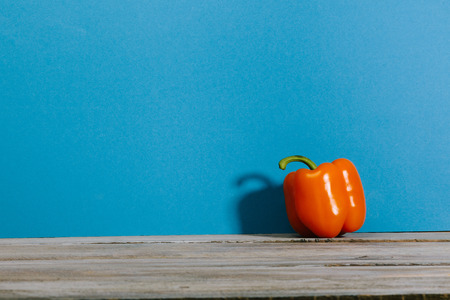 Pepper on wood table with bright blue color backgroundの写真素材