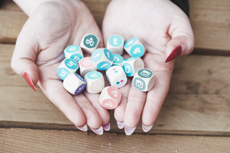 BERLIN, APRIL 5, 2018: Young business person holding cubes with logos of multiple social network websites, symbolic image for management of online public relation through multiple channels.のeditorial素材