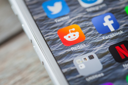 BERLIN, GERMANY - JUNE 6, 2018: Close up to app of social media community Reddit on the screen of an iPhone 7 Plus with personalized background.のeditorial素材