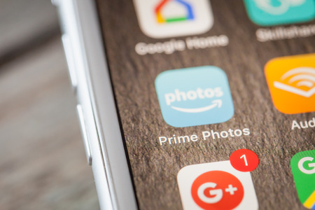 BERLIN, GERMANY - JUNE 6, 2018: Close up to Amazon Prime Photos cloud storage app on the screen of an iPhone 7 Plus with personalized background.のeditorial素材