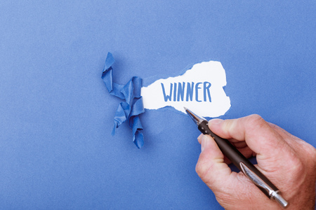 Winner revealed as hand written word from shreds of ripped pieces of cardboard paperの写真素材