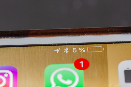 BERLIN, GERMANY - OCTOBER 20, 2018: Focus on very low battery warning on screen of an iPhone 7 Plus...
