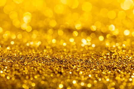Gold glitter macro close-up texture with shallow depth of field and bokeh background, luxury value concept for christmas or birthday greetings and presentsの写真素材