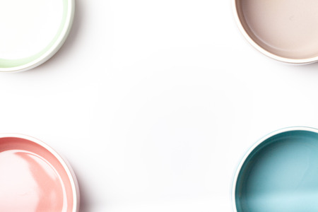 Border frames with set of empty pastel colored bowls with copy space, isolated on white backgroundの写真素材