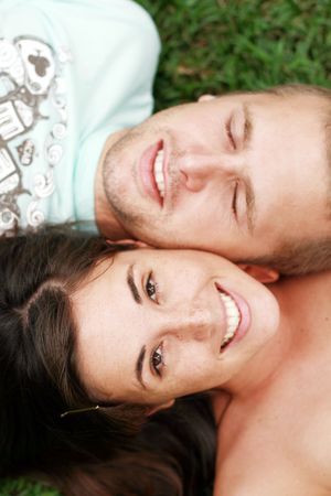 happy couple lying on grass