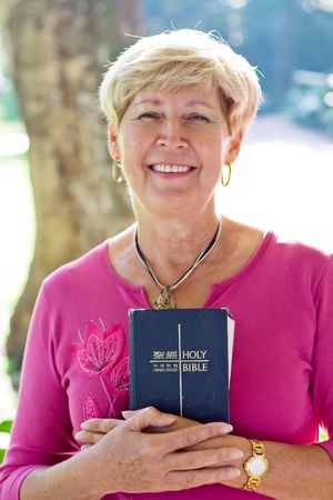 happy senior woman holding a bibleの写真素材
