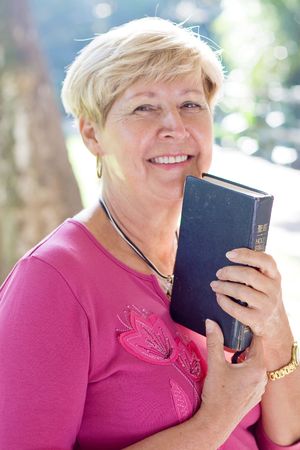 happy senior woman holding a bibleの写真素材