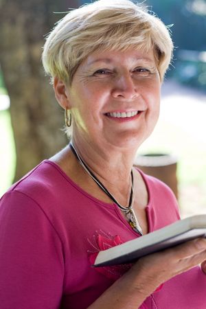 happy senior woman reading a bible