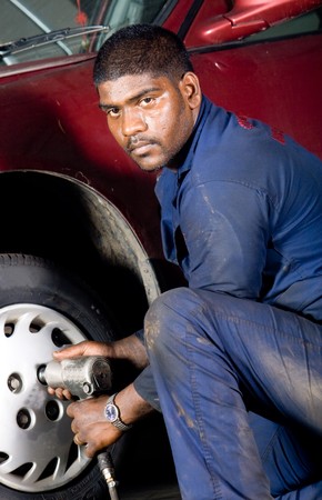 indian mechanic changing vehicle tyreの写真素材