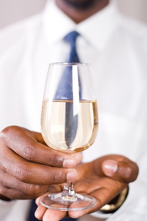 hands presenting a glass of wineの写真素材