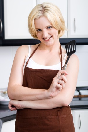 cute young blond woman in kitchenの写真素材