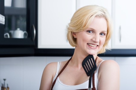 cute young blond woman in kitchenの写真素材