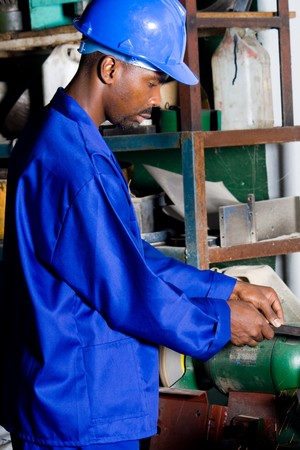 African machinist operating a grinding machineの写真素材