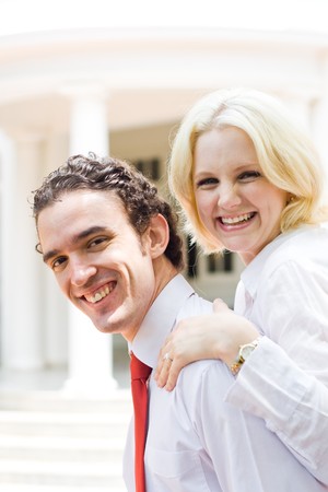 young couple hugging in front of their homeの写真素材