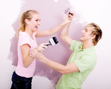 couple having fun while painting houseの写真素材