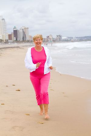 senior exercise woman jogging on beachの写真素材