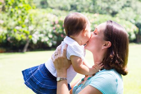 mother kissing baby daughterの写真素材
