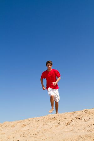 teen boy running on beachの写真素材