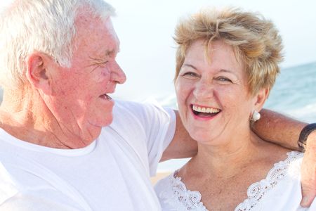 laughing senior couple on beach