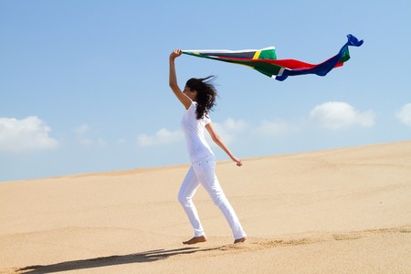 pretty woman holding south african flag on beachの写真素材
