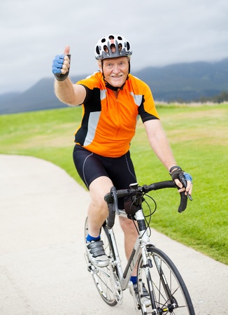 happy senior male bicyclist giving thumb up on bicycleの写真素材