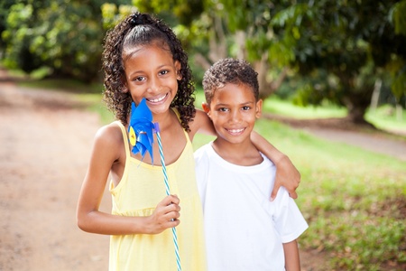happy sister and brother with pinwheel outdoors