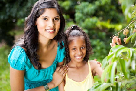 beautiful young mother and daughter in litchi orchard