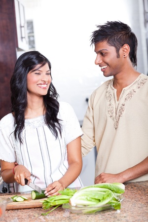 happy indian couple cooking in kitchenの写真素材
